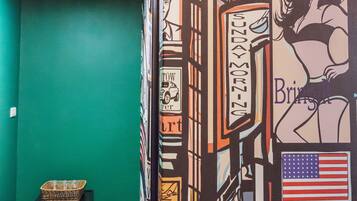 A room with a green wall, a black cabinet, and a patterned wall with various signs and illustrations.