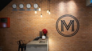 A reception desk with clocks indicating time in London, Beijing, Seoul, and Seoul. - Monaco Boutique Hotel Kampung Air (Kota Kinabalu)