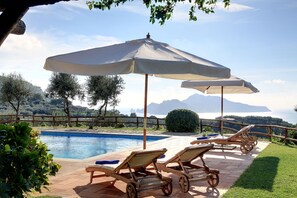 Piscine extérieure en saison, chaises longues