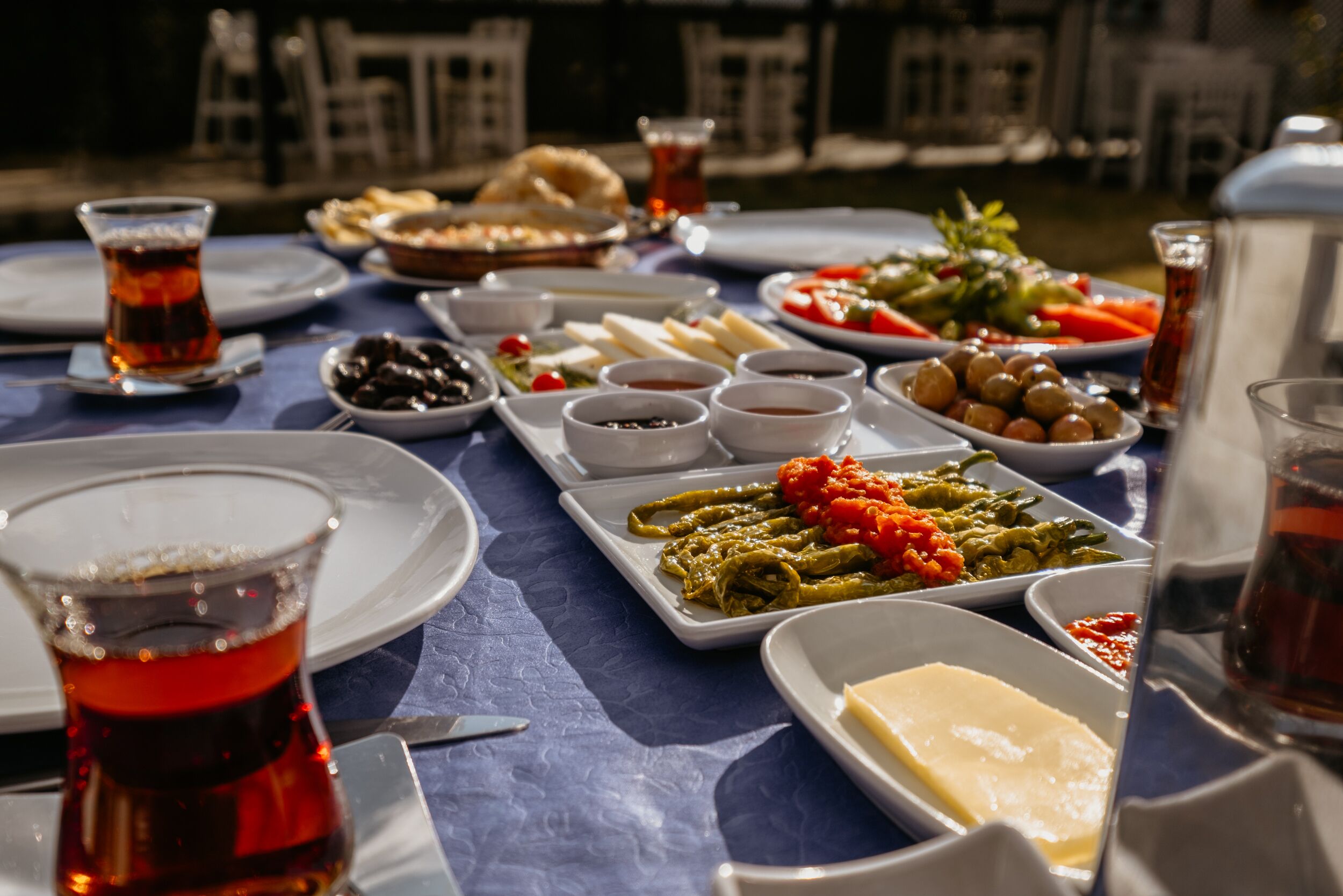 Una mesa dispuesta con diversos platos, incluyendo aceitunas, queso y verduras, con vistas a edificios al fondo.