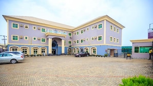 A large building with a central entrance, multiple windows, and a paved courtyard. - Royal Terrace Hotel & Towers (Lagos)