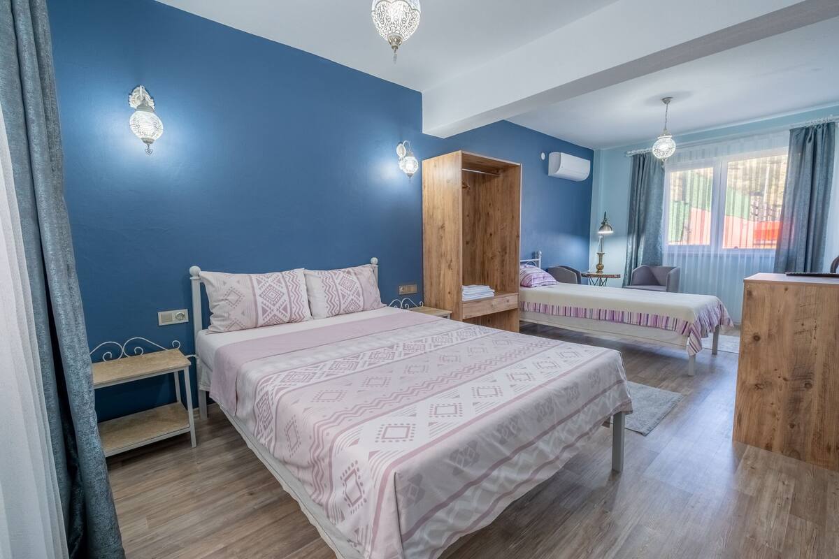 Ein Schlafzimmer mit einem großen Bett, einem Holzschrank, einem Schreibtisch und einem Stuhl.