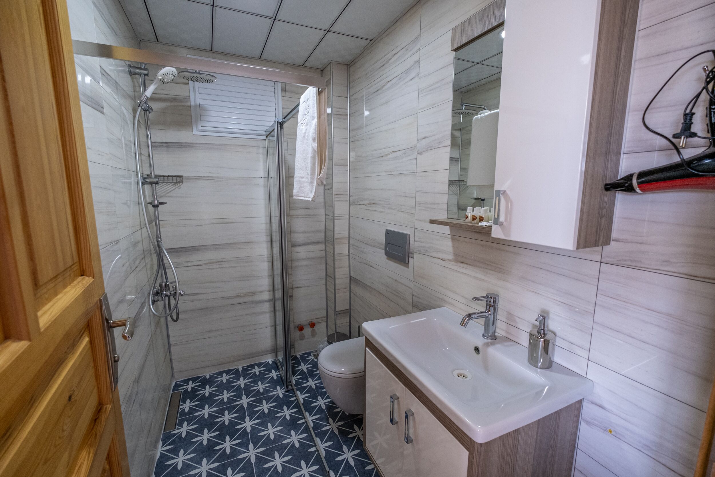 Une salle de bain moderne équipée d’une douche, de toilettes et d’un lavabo.