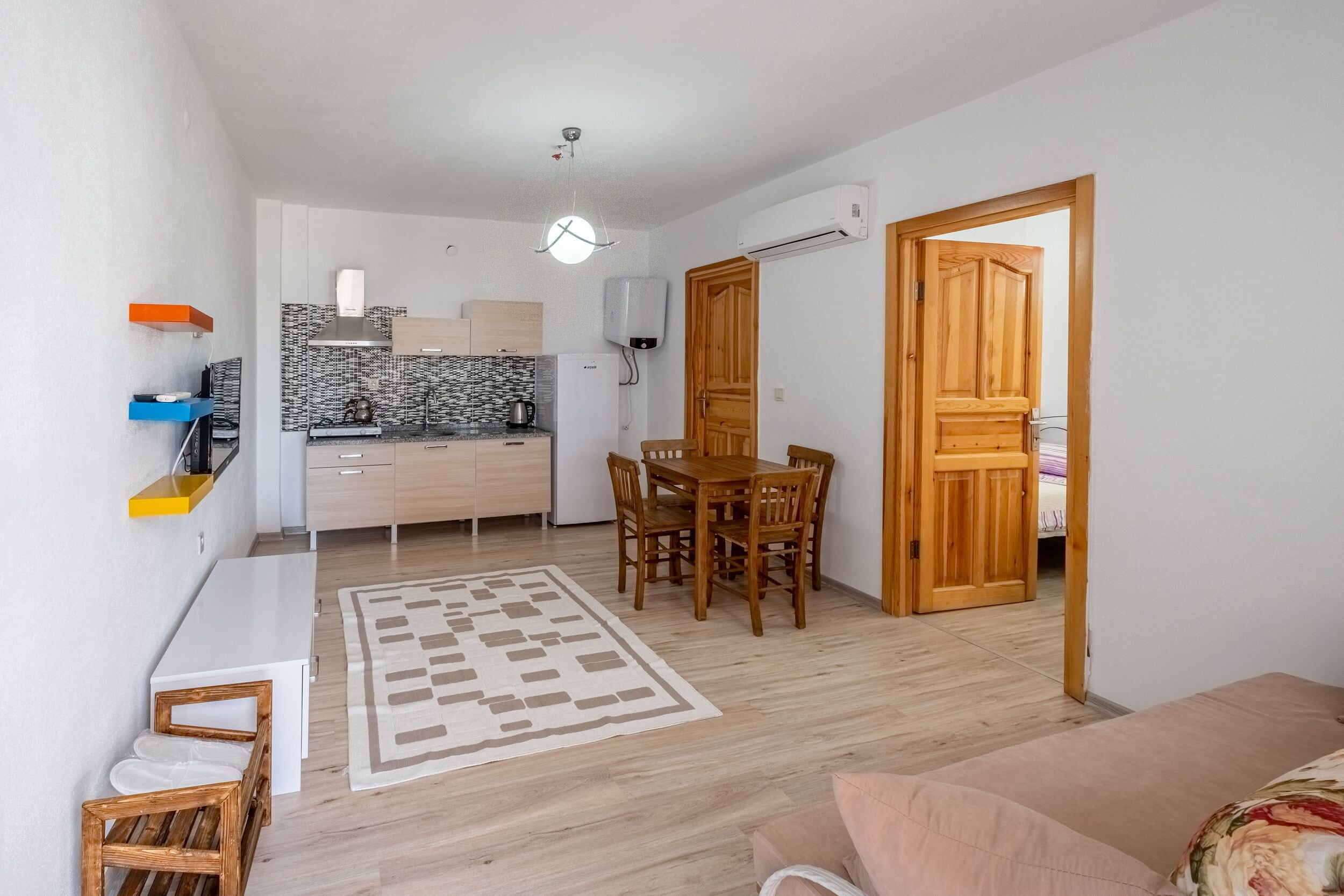 A compact living space with a kitchenette, dining area, and a sofa.