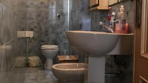 Une salle de bain équipée de toilettes, d’un bidet et d’un lavabo.