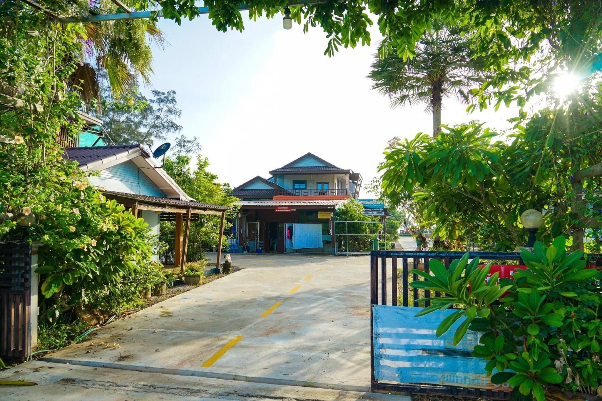 A gated entrance to a building with a blue roof and a signboard.