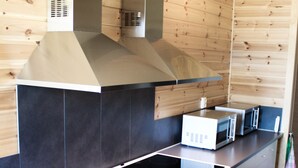 Una cocina moderna con estufa negra, horno blanco y campana extractora de acero inoxidable.