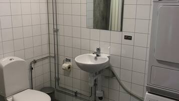 A bathroom with a toilet, sink, and washing machine.