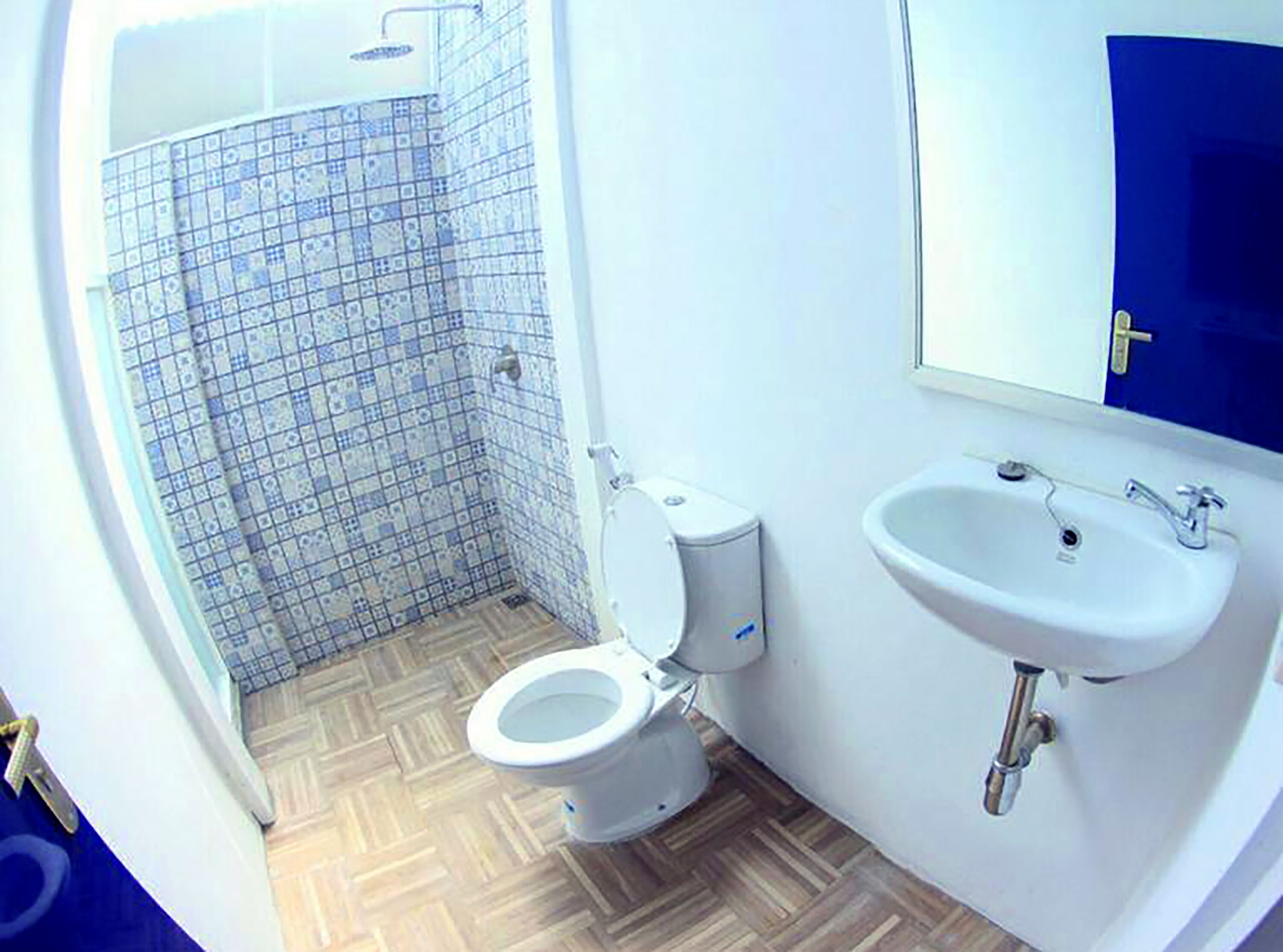A bathroom with a toilet, sink, and shower.