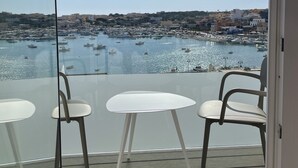 Ein Balkon mit freiem Blick auf einen Jachthafen und Gebäude in der Ferne.