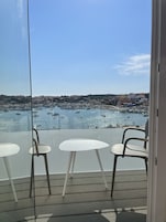 Un balcón con vistas despejadas a un puerto deportivo y edificios a lo lejos.