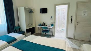A hotel room with two beds, a desk with a chair, a television, and a wardrobe.