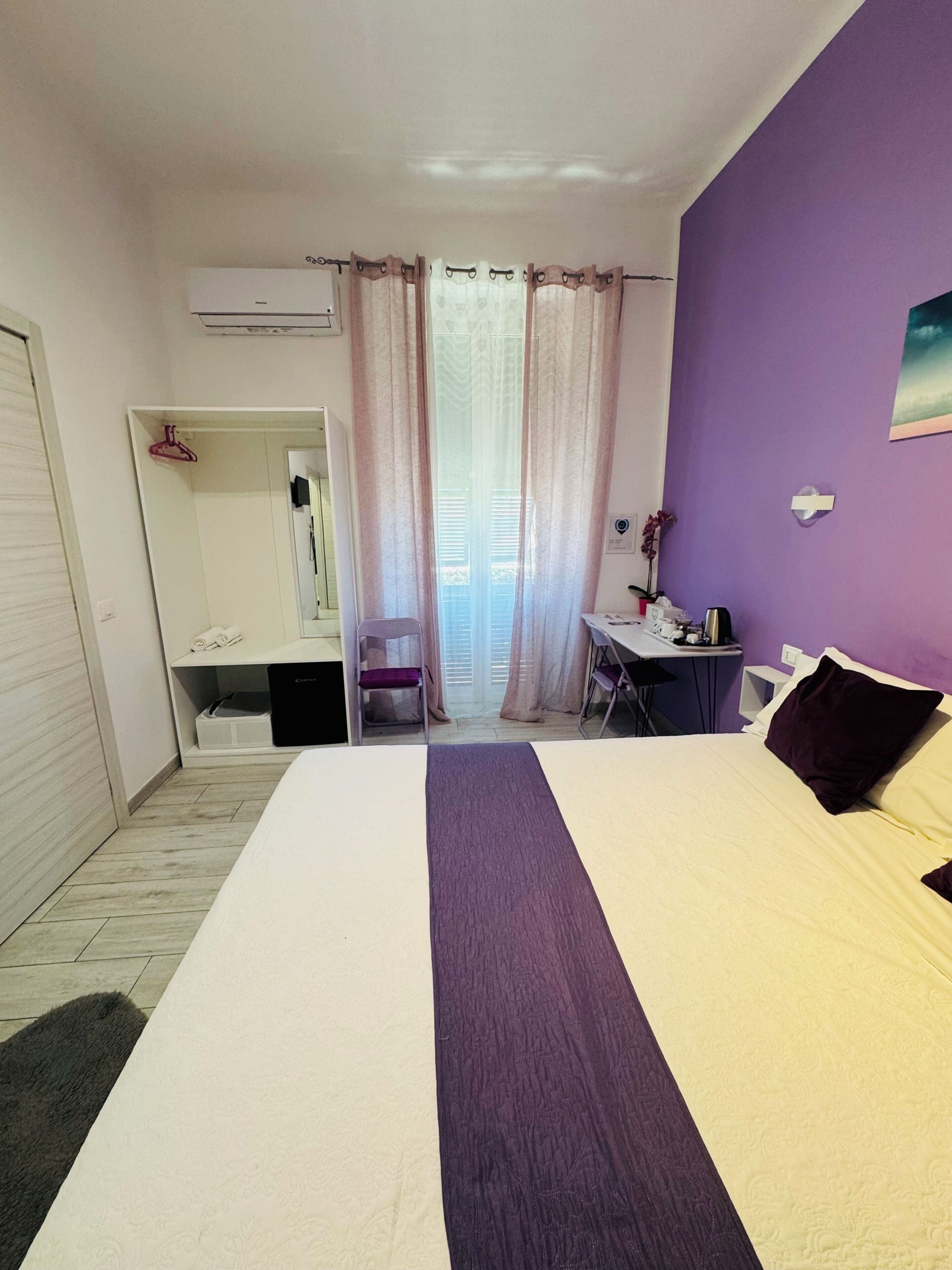 Una camera da letto con un letto, una scrivania, una sedia e un armadio.