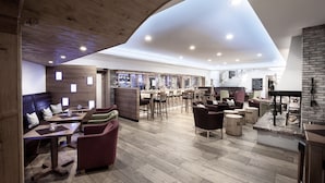 A spacious restaurant with wooden flooring, multiple seating areas, and a high ceiling with recessed lighting. - Hotel Seeblick (Bad Reichenhall)