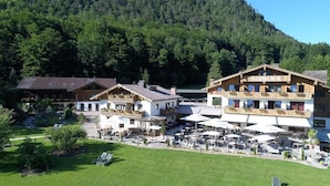 A mountain lodge with outdoor seating and a view of the forested hills. - Hotel Seeblick (Bad Reichenhall)