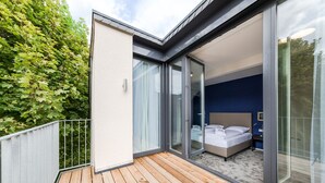 Ein modernes Schlafzimmer mit einer großen Schiebeglas-Tür, die auf einen Balkon führt.