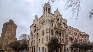 Un edificio histórico con arquitectura ornamentada, que incluye una torre y varios balcones.