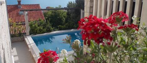 Una piscina al aire libre, sillones reclinables de piscina