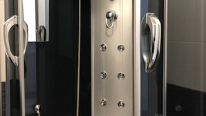 Eine moderne Duschkabine mit Bedienfeld, Duschbrause und Handbrause.