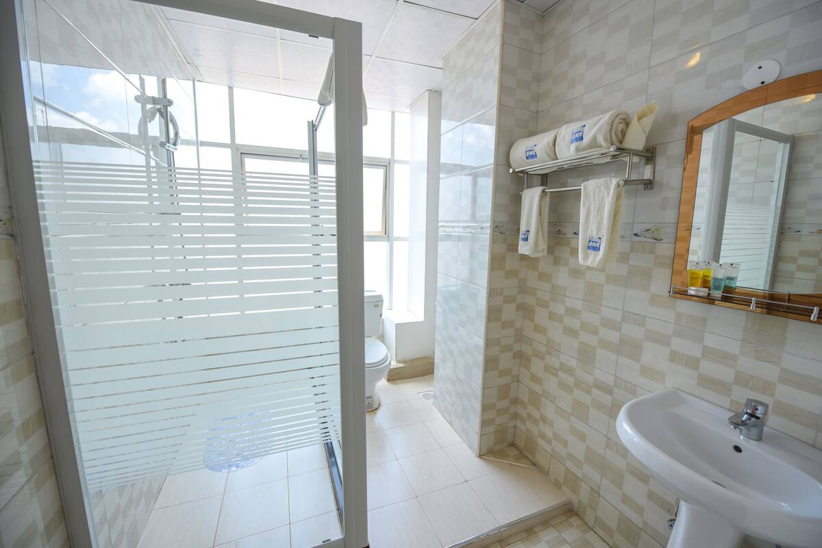 A bathroom with a glass shower door, a sink, and a toilet.