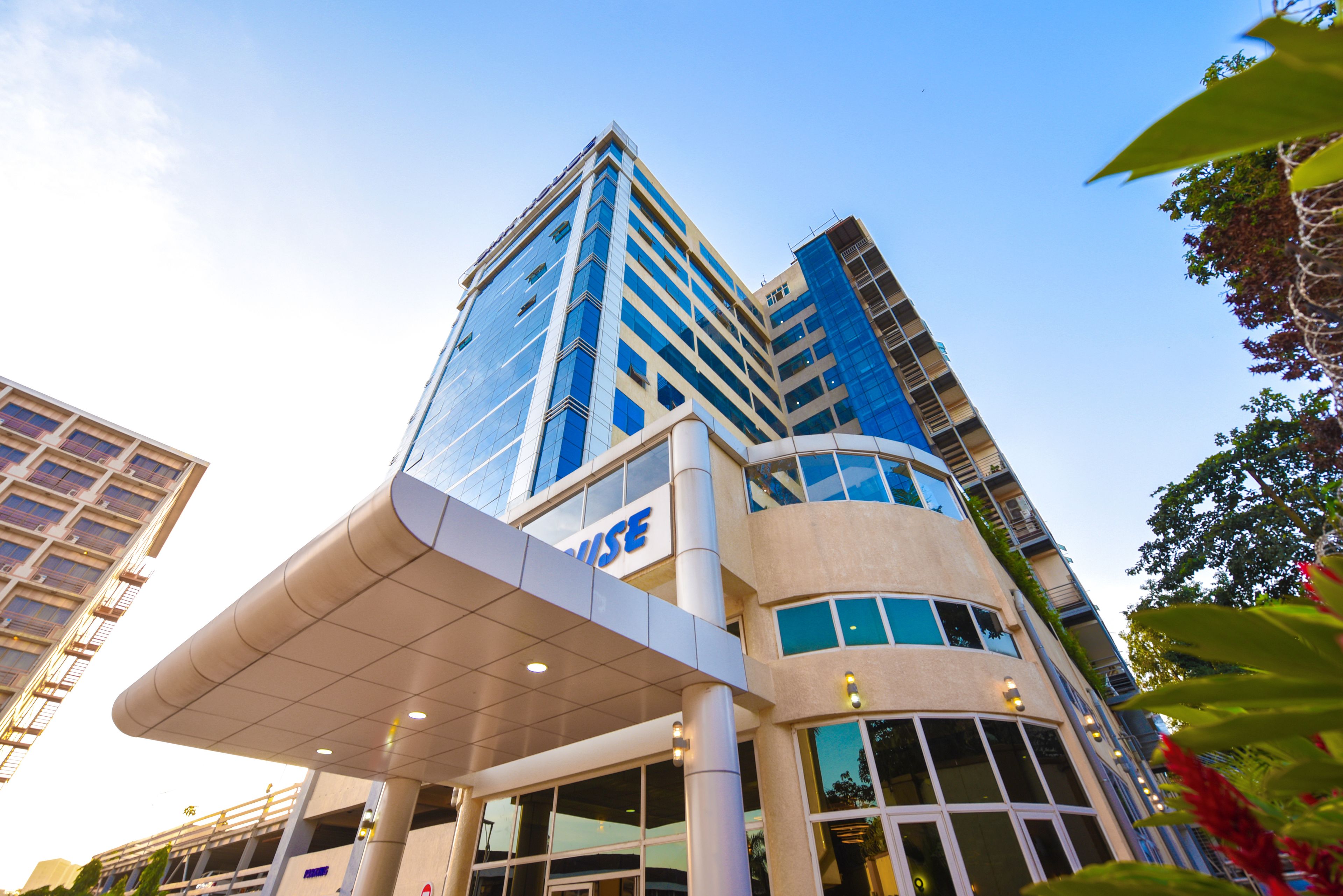 A modern hotel with a prominent glass facade, a covered entrance, and multiple floors.