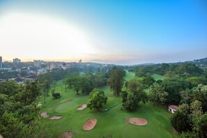 Una piscina al aire libre, sombrillas, sillones reclinables de piscina