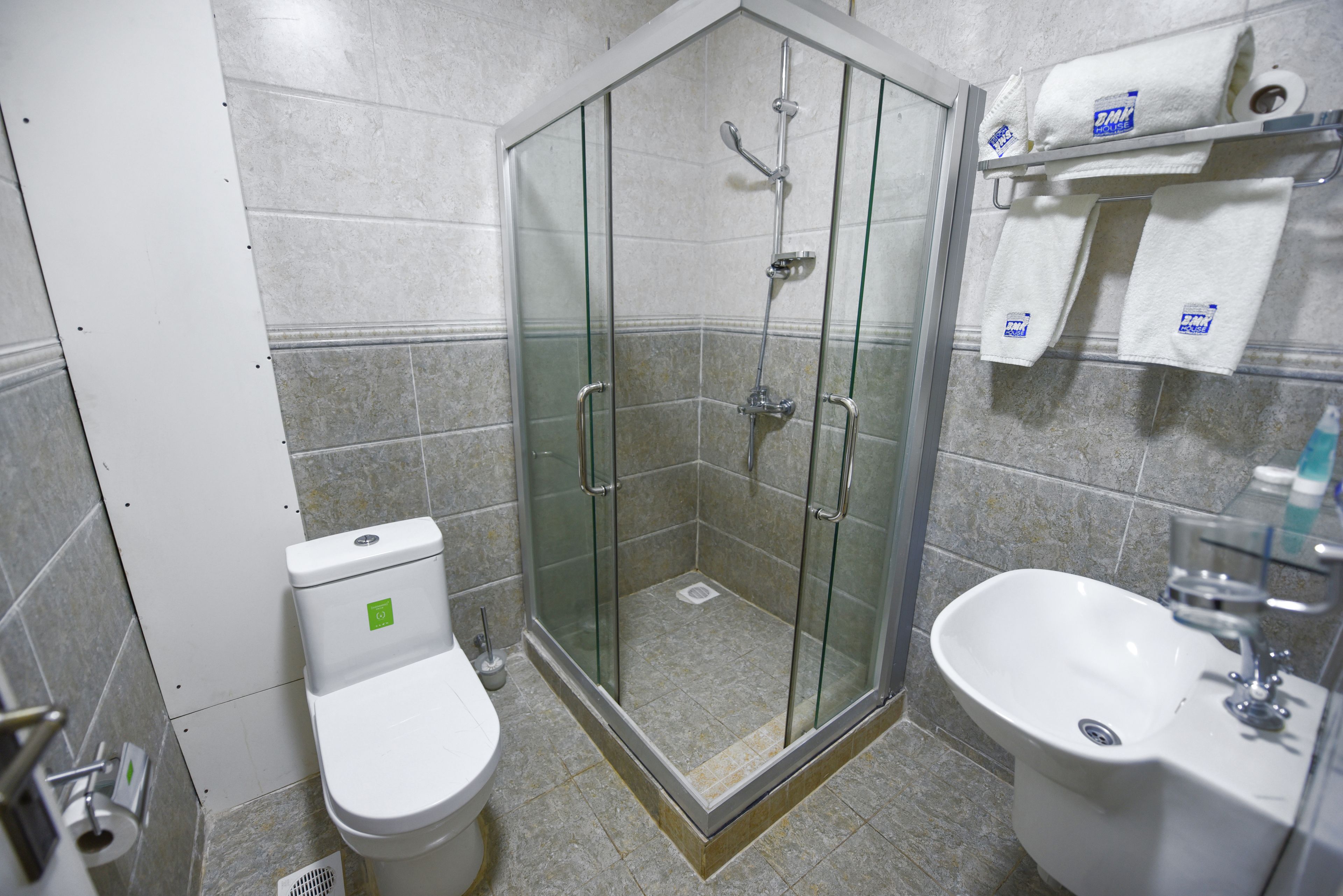 Un baño con ducha de vidrio, inodoro y lavamanos.