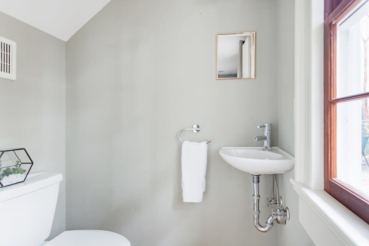 Une salle de bain avec des toilettes, un lavabo et une fenêtre.