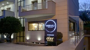 Een modern hotel met een bordje voor Mirivili kamers & suites en een spa & wellnesscentrum.