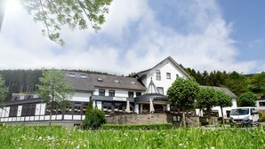 Un hôtel doté d’un restaurant, d’une façade en pierre et d’un espace de stationnement.