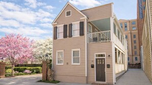A two-story residential building with a balcony on the upper floor, a brick entrance, and a number "39" on the door.