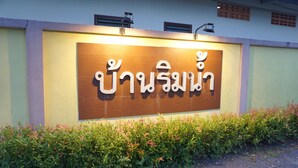 A sign with Thai script on a building facade. - Baan Rim Nam Resort (Phang Nga)