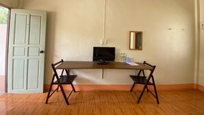 A room with a wooden table, two chairs, a television, and a mirror on the wall. - Baan Rim Nam Resort (Phang Nga)