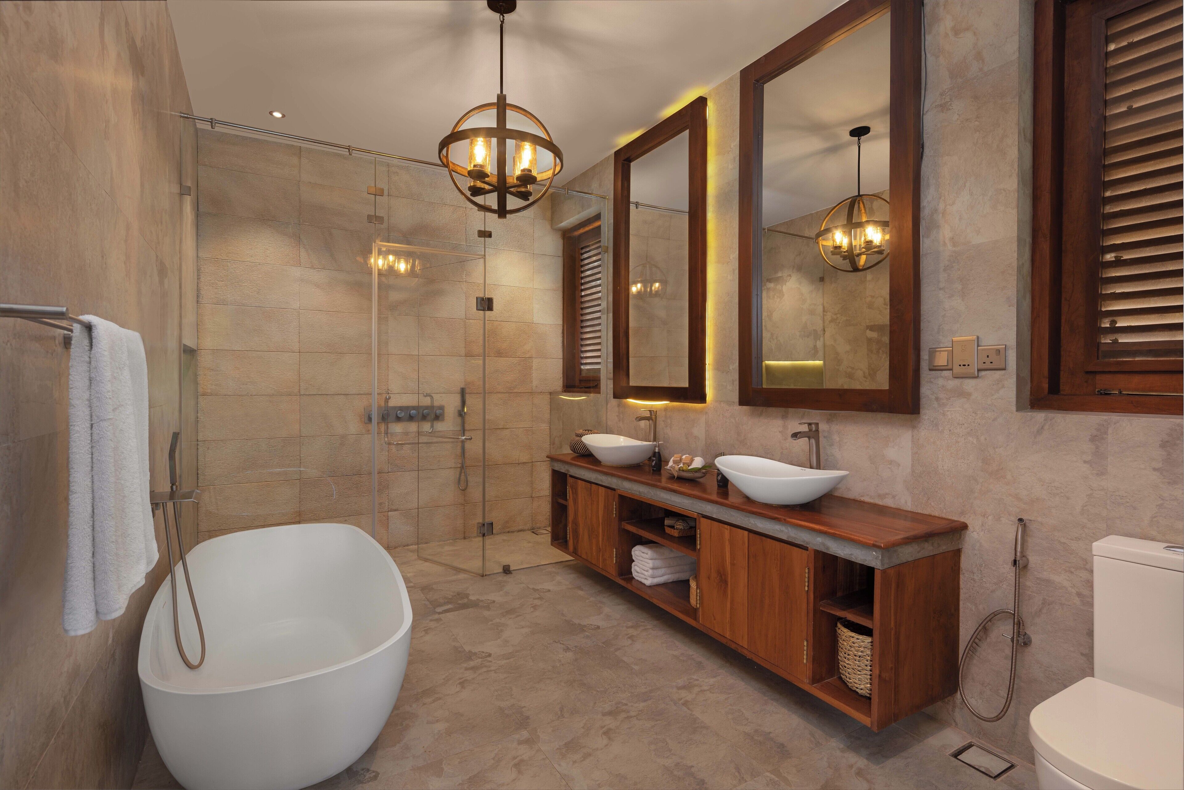 Ein modernes Badezimmer mit einer freistehenden Badewanne, einem großen Spiegel und einem Holzbadezimmer-Möbel mit zwei Waschbecken.