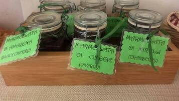 Des pots de confiture d’agrumes dont les étiquettes indiquent les saveurs, comme la cerise noire et la canneberge.