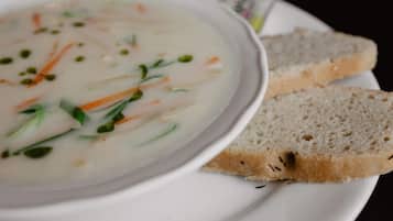 Un tazón de sopa con verduras y rebanadas de pan en un plato.