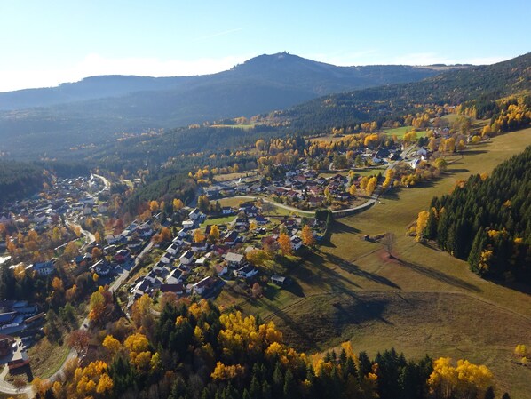 An aerial view of a town with houses, roads, and surrounding hills.