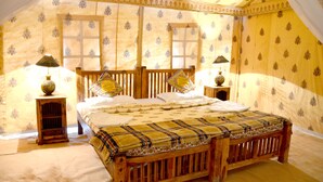 A bedroom with a wooden bed, two bedside tables, and a canopy bed. - The Chirag Desert Camp Sam Sand Dunes (Jaisalmer)