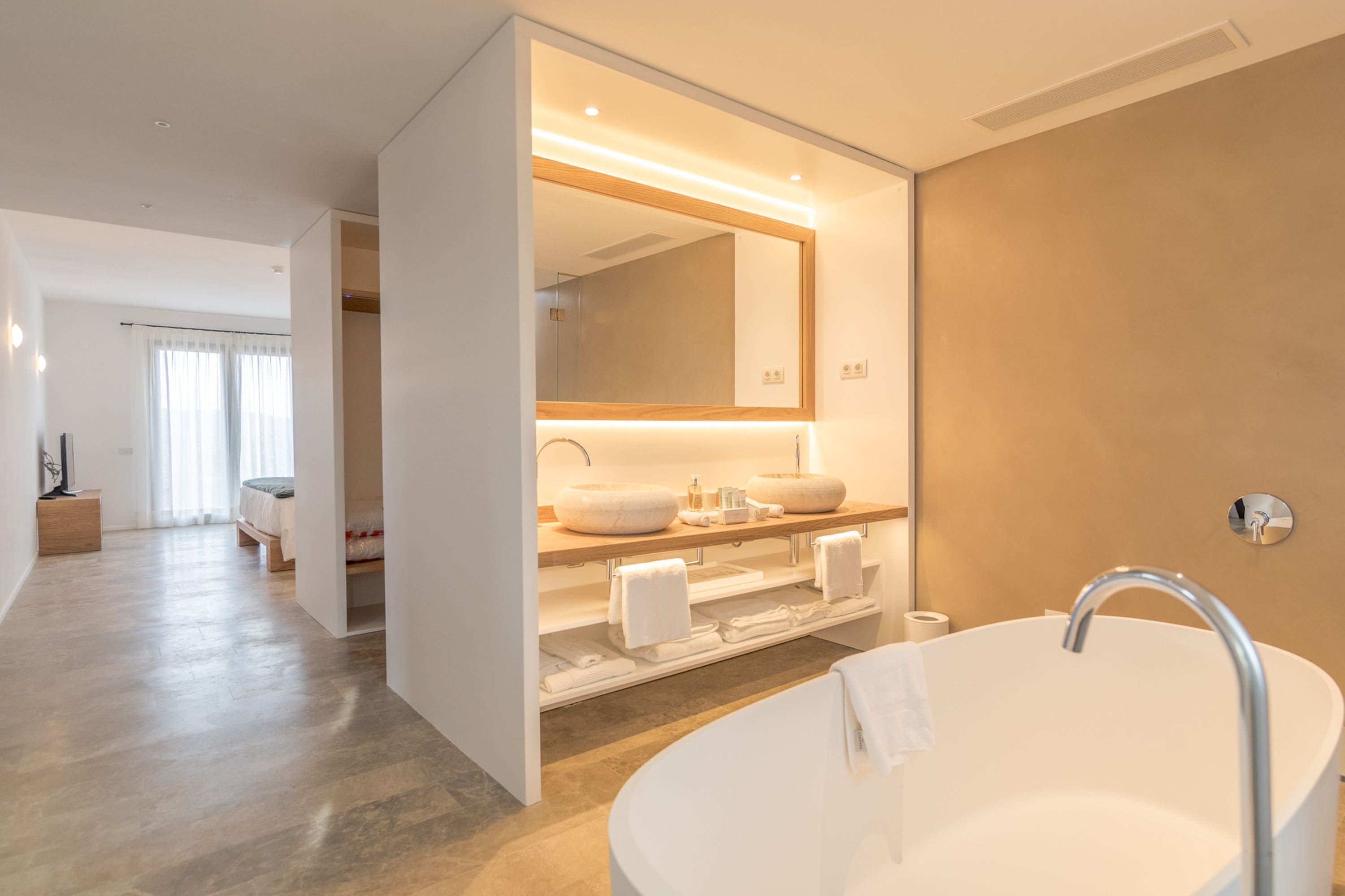 Une salle de bain moderne avec une baignoire sur pieds, un grand miroir et un meuble-lavabo doté de deux vasques.