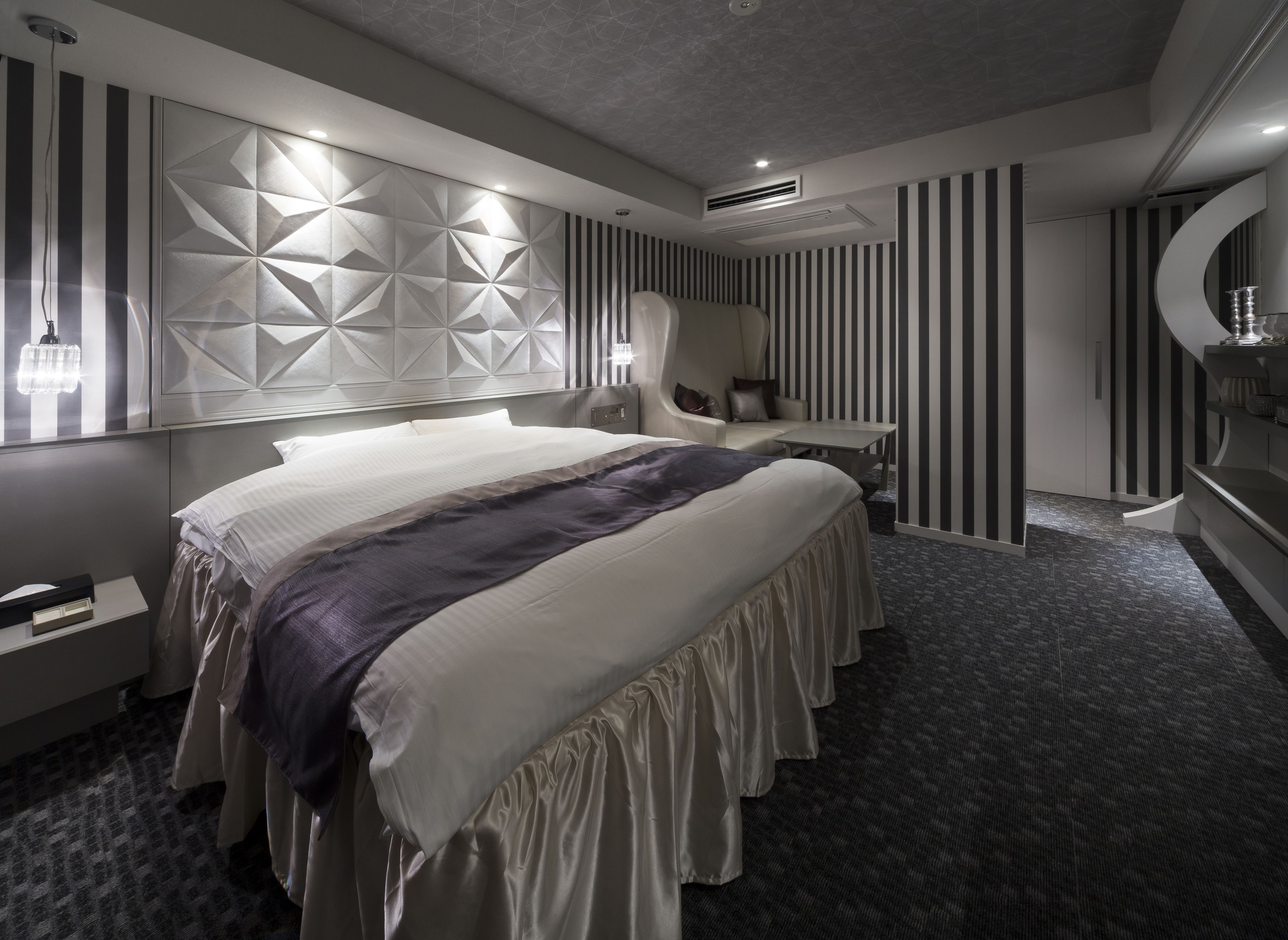 Una habitació d'hotel moderna amb un llit gran, una zona de seients i un taulell de tocador.