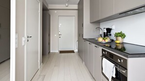 A modern kitchen with grey cabinets, a black countertop, and a stainless steel oven. - Forenom Apartments Stockholm Johannesgatan (Stockholm)
