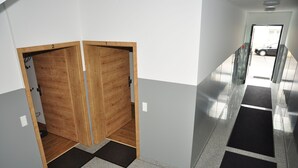 A hallway with a wooden door labeled '2' and a black mat at the entrance. - Ebersheim Luxus Plaza (Mainz)
