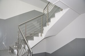 A modern staircase with glass railings and granite steps. - Ebersheim Luxus Plaza (Mainz)