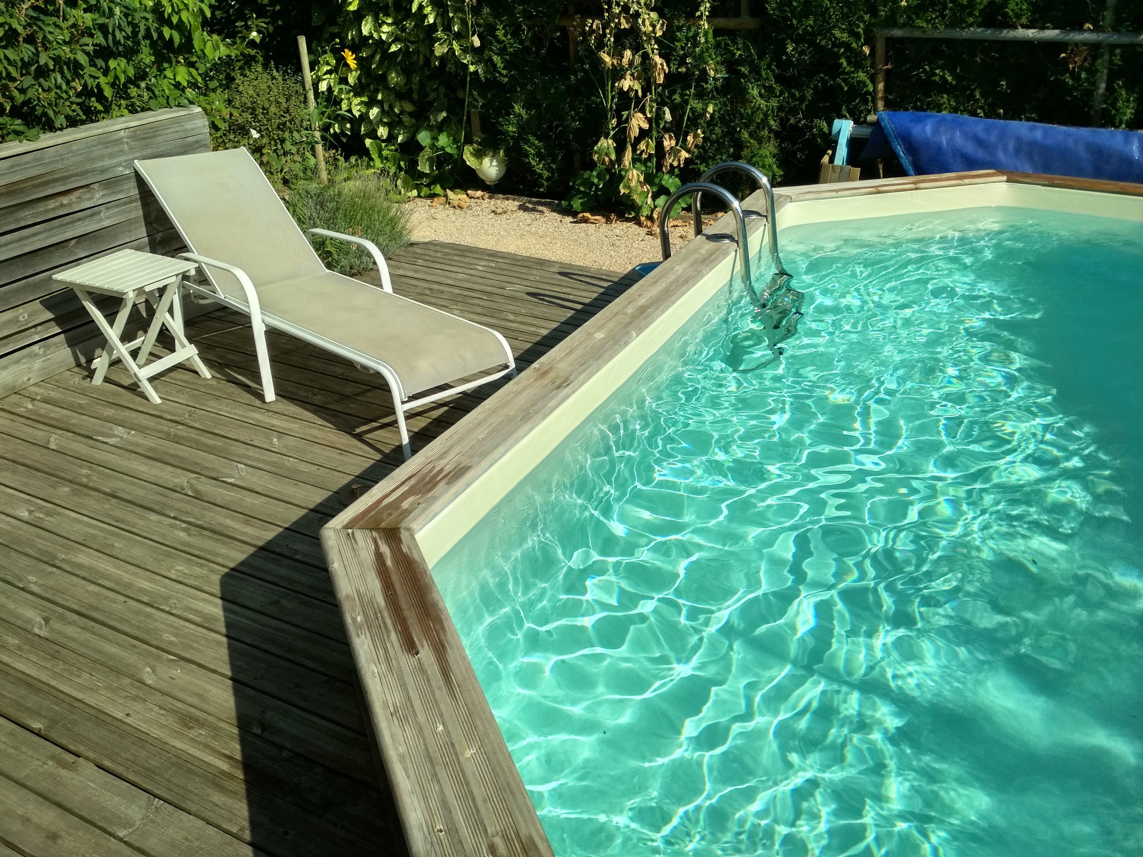 Een seizoensgebonden buitenzwembad en ligstoelen