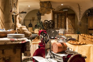 Una cocina rústica con un cortador de carne, muebles de madera y paredes de piedra.
