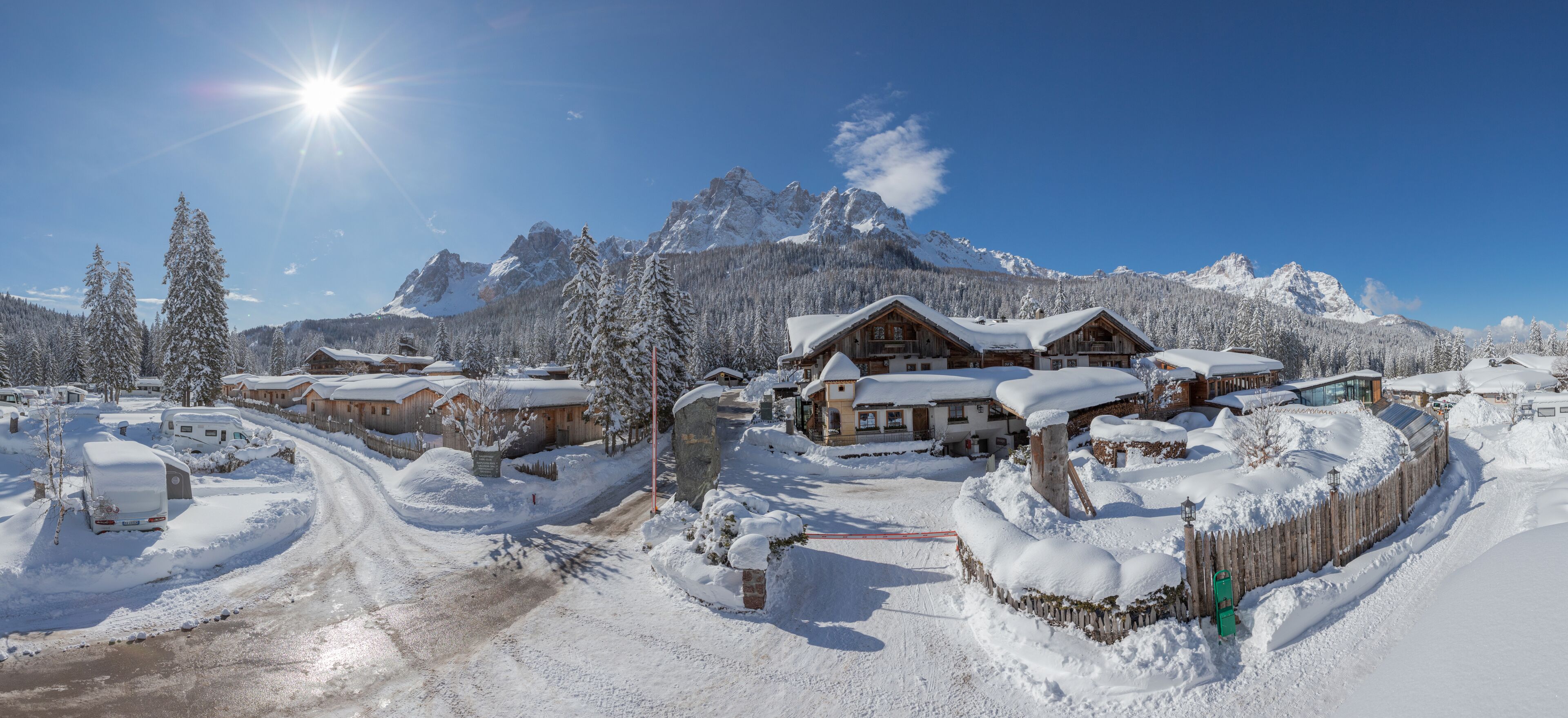 A snow-covered mountain resort with wooden cabins and a clear sky.