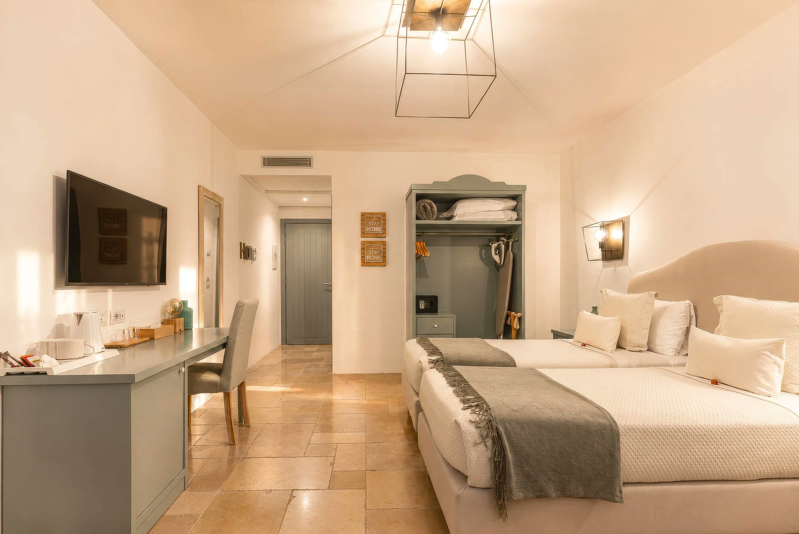 Habitación de hotel con cama, mesita de noche, televisión y escritorio con silla.