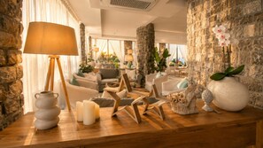A well-lit living area with stone walls, a wooden coffee table, and various decorative items.