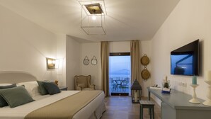 A hotel room with a bed, a desk, a television, and a balcony with a view. - Romantic Relais Sorrento (Sorrento)