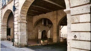 Un paso subterráneo con arcos de piedra y un camino adoquinado.